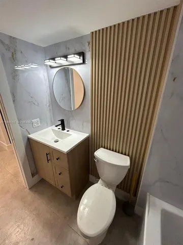 a bathroom with a granite countertop sink toilet a mirror and shower
