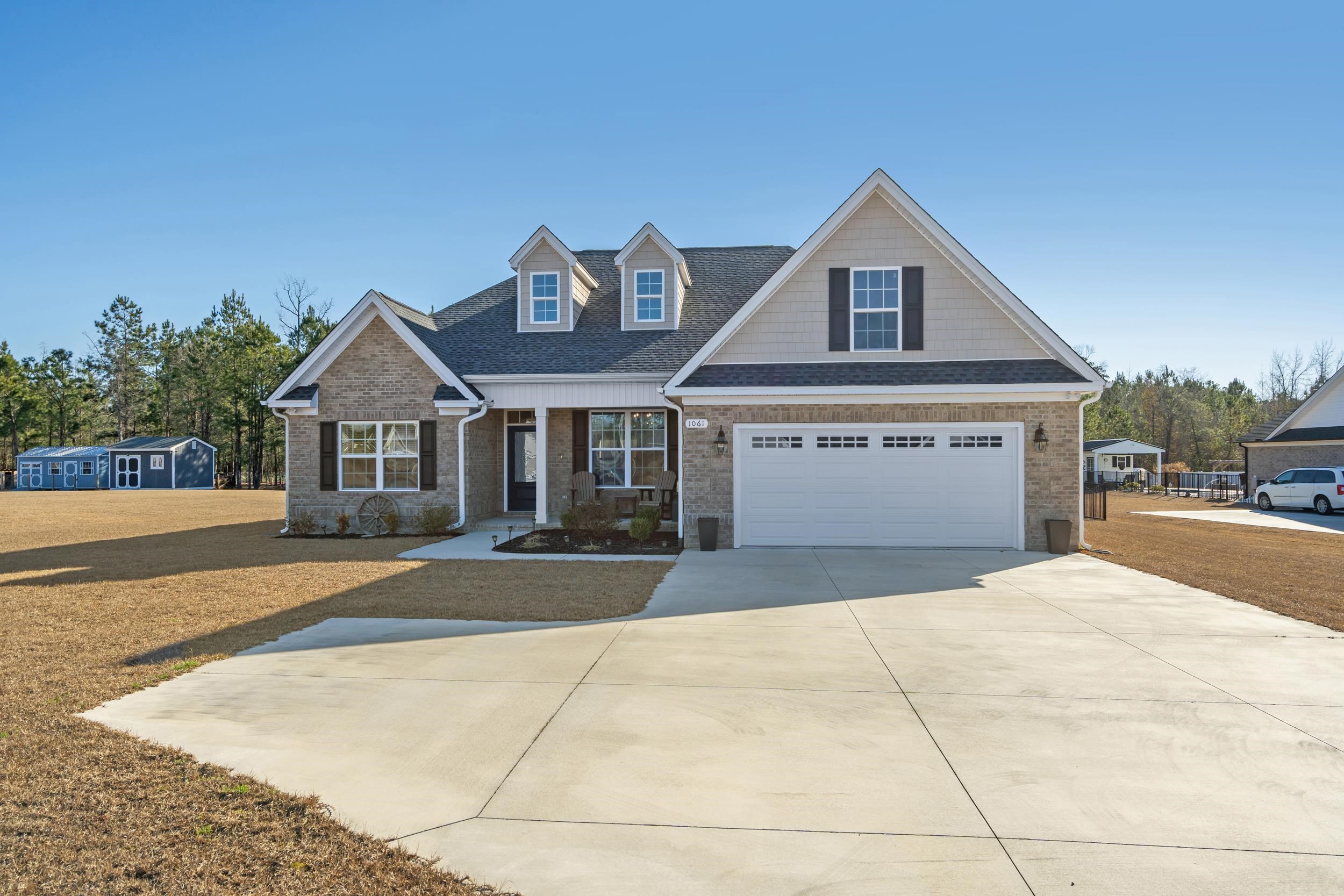 1061 Busy Corner Road Conway, SC 29527 - Photo 2 of 37 View of front of house with a shingled roof, concrete driveway, brick siding, and a front yard