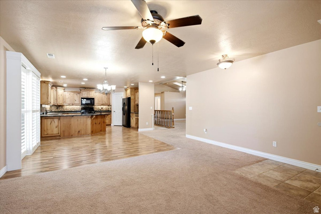 1089 West 2325th Street North Layton, UT 84041 - Photo 6 of 40 Open-concept interior featuring wood-finish flooring, recessed lighting, ceiling fan, and a kitchen with wood cabinetry and dark countertops