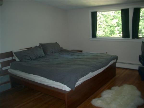 8 Mason Street Lexington, MA 02421 - Photo 13 of 14 a bed sitting in a bedroom next to a window