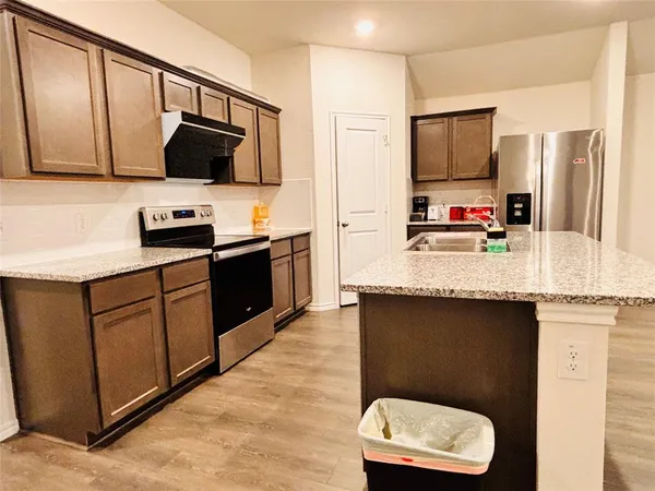 a kitchen with stainless steel appliances granite countertop a sink refrigerator and microwave