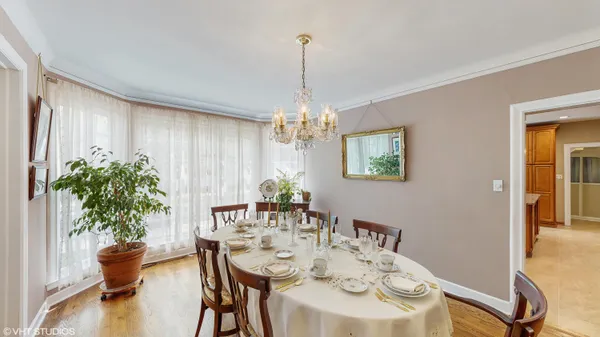 a kitchen with stainless steel appliances granite countertop table chairs sink refrigerator and microwave