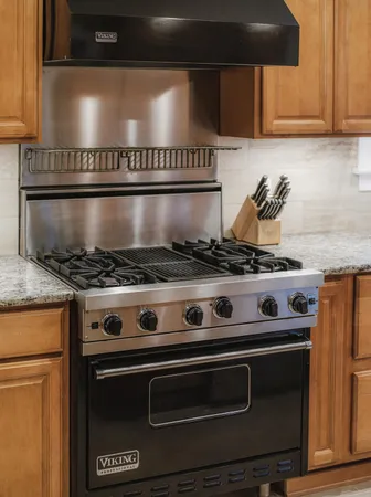 a kitchen with granite countertop a sink appliances and cabinets