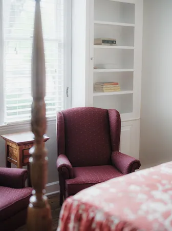 a bedroom with a bed a table and a chandelier