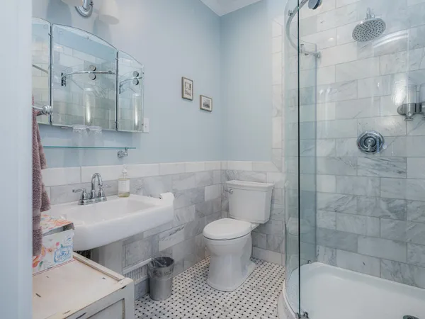 a bathroom with a granite countertop sink a mirror and shower