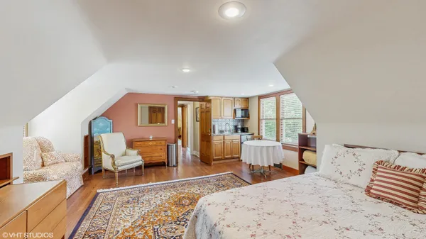 a view of a deck with a bench and large trees