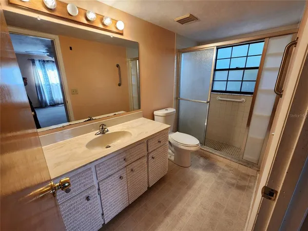 a bathroom with a double vanity sink toilet and mirror