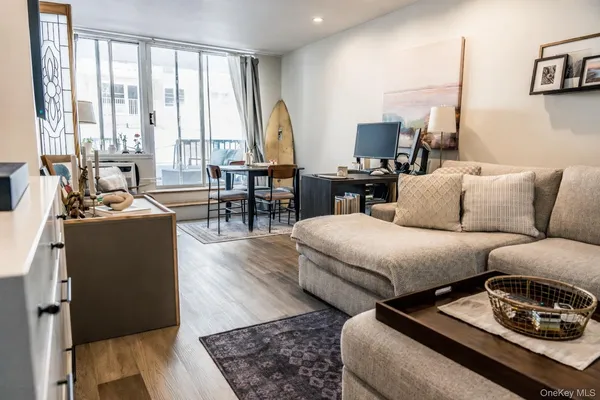 a living room with furniture a large window and a flat screen tv