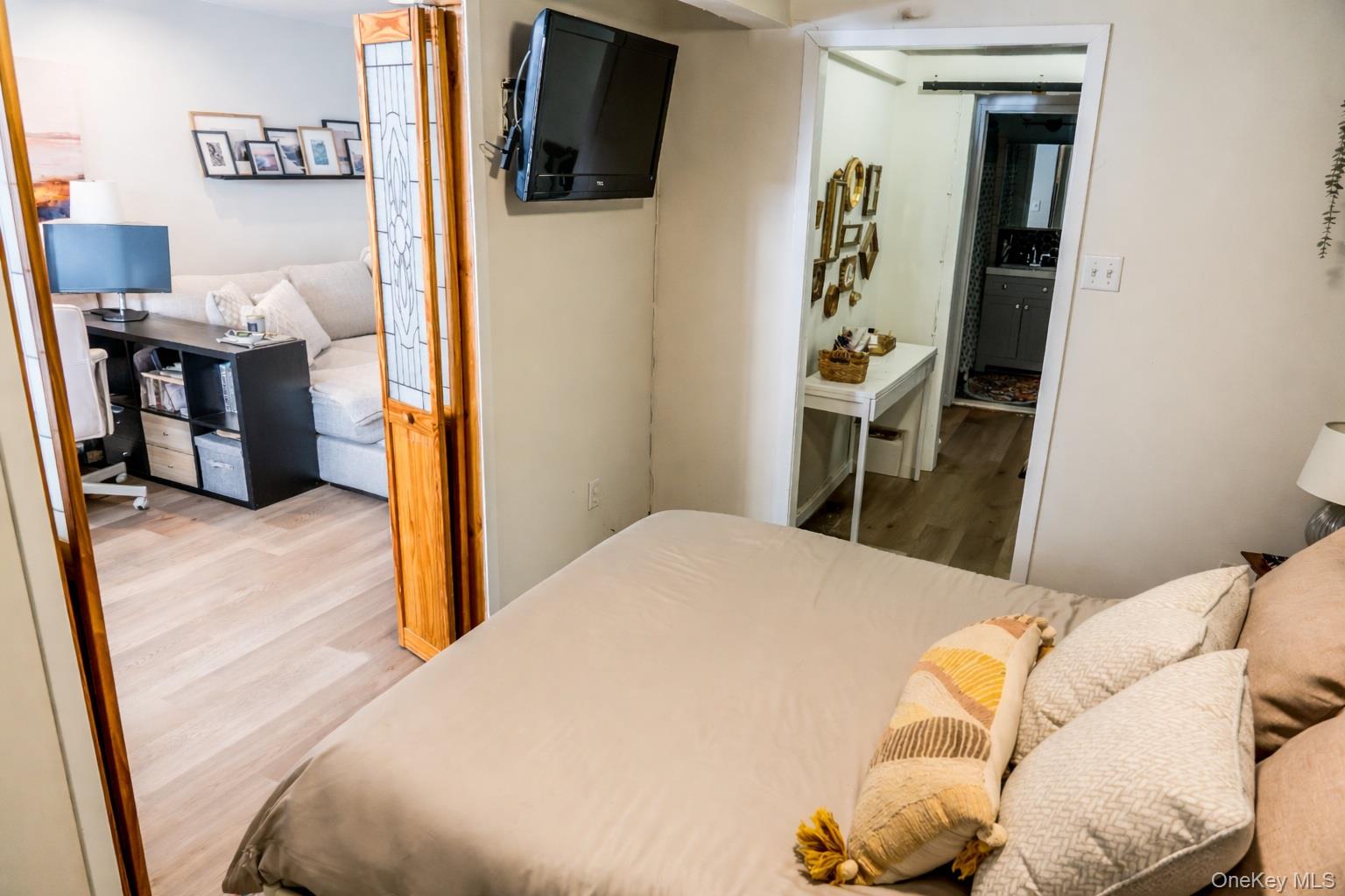 650 Shore Road, Unit 1C Long Beach, NY 11561 - Photo 12 of 21 a bedroom with a bed and a flat screen tv