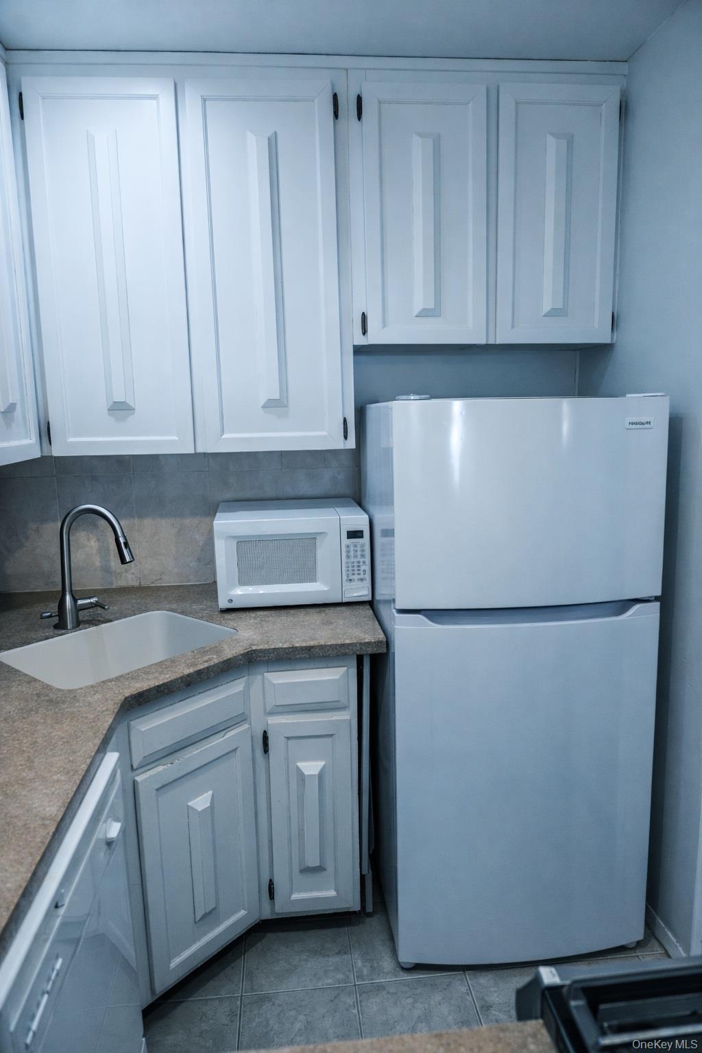 650 Shore Road, Unit 1C Long Beach, NY 11561 - Photo 9 of 21 a white refrigerator freezer sitting in a kitchen