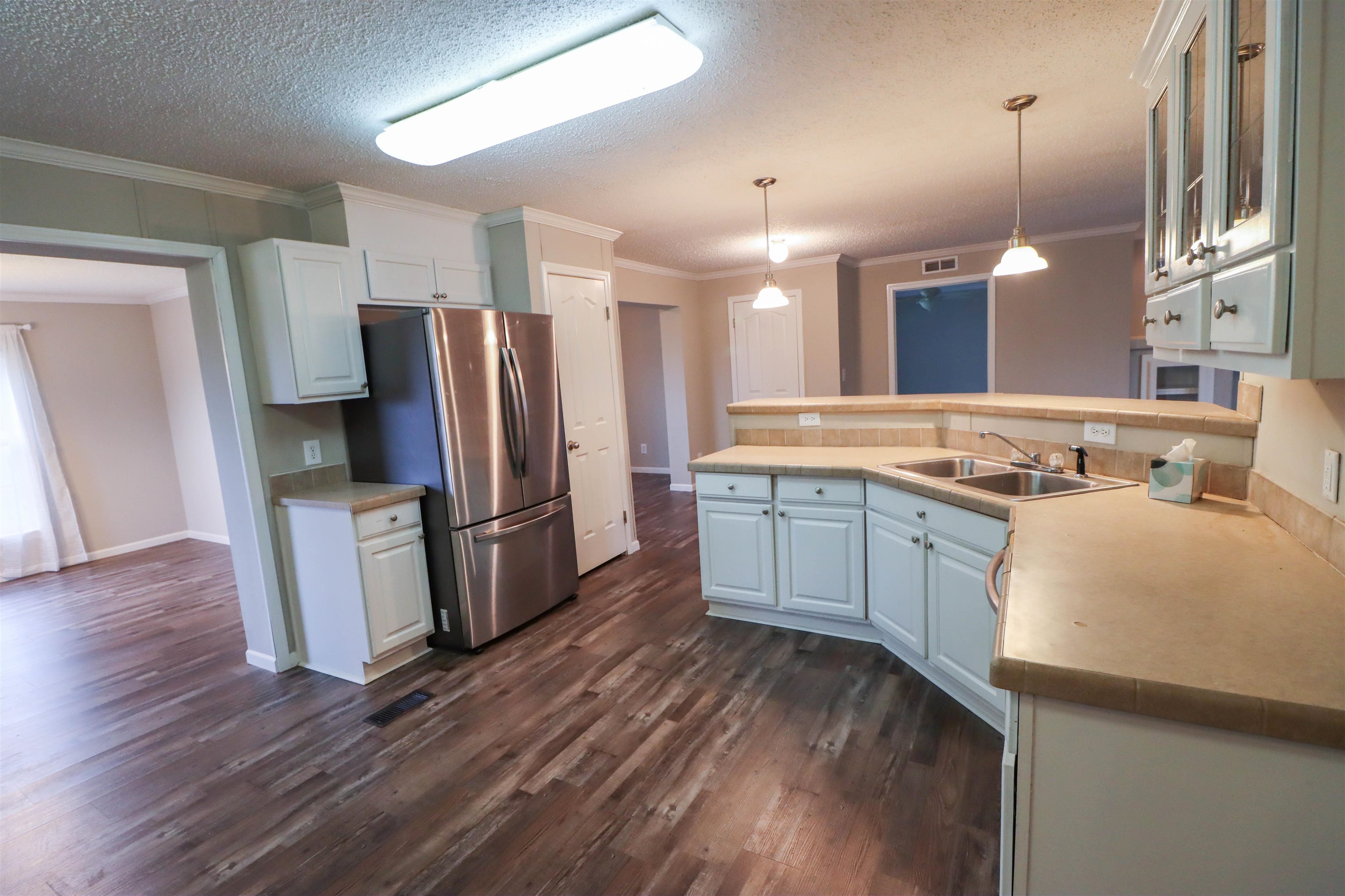 2914 Hobe Webb Road Ripley, TN 38063 - Photo 15 of 29 a kitchen with refrigerator cabinets and wooden floor