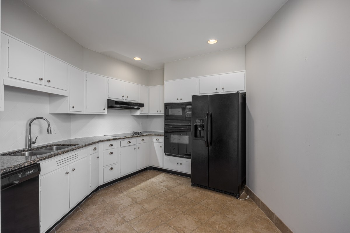 4215 Harding Pike, Unit 1203 Nashville, TN 37205 - Photo 17 of 43 a kitchen with granite countertop a refrigerator and cabinets