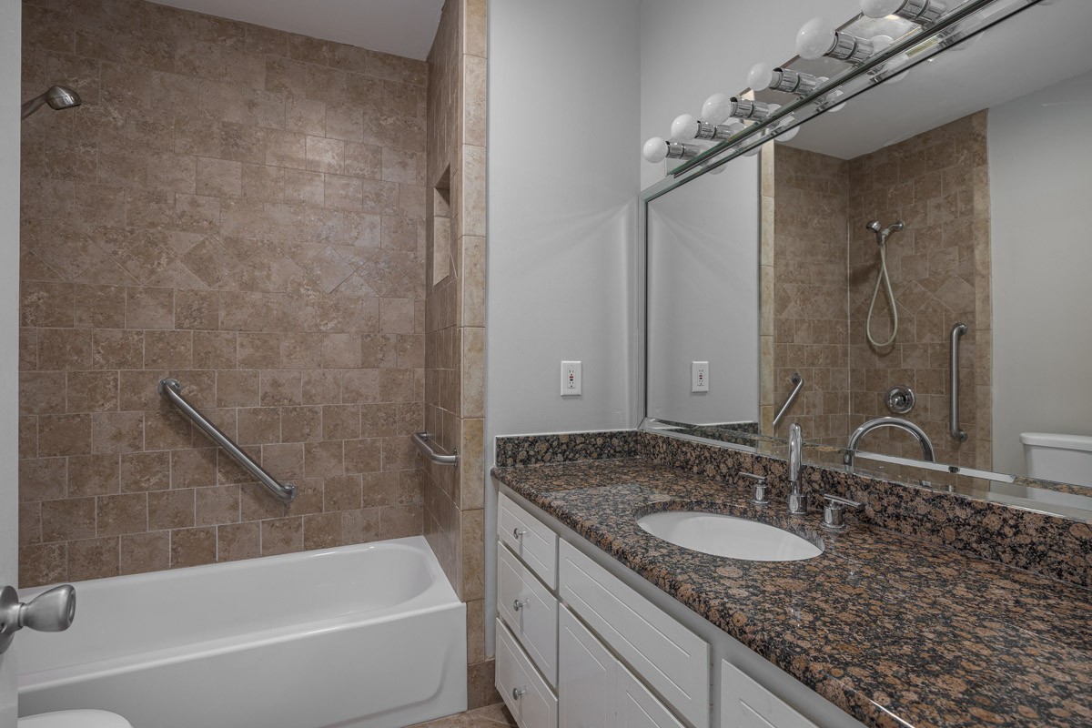 4215 Harding Pike, Unit 1203 Nashville, TN 37205 - Photo 24 of 43 a bathroom with a granite countertop sink a mirror and a bathtub