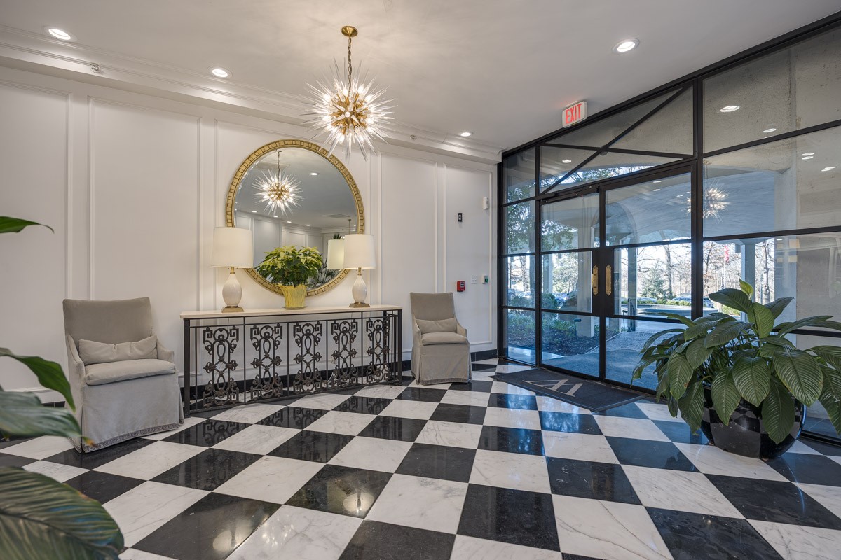 4215 Harding Pike, Unit 1203 Nashville, TN 37205 - Photo 5 of 43 a living room with a black white checkered floor with a gaming machine and glass windows