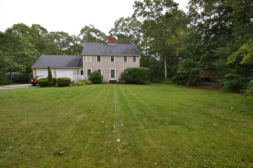 a front view of a house with a yard and trees