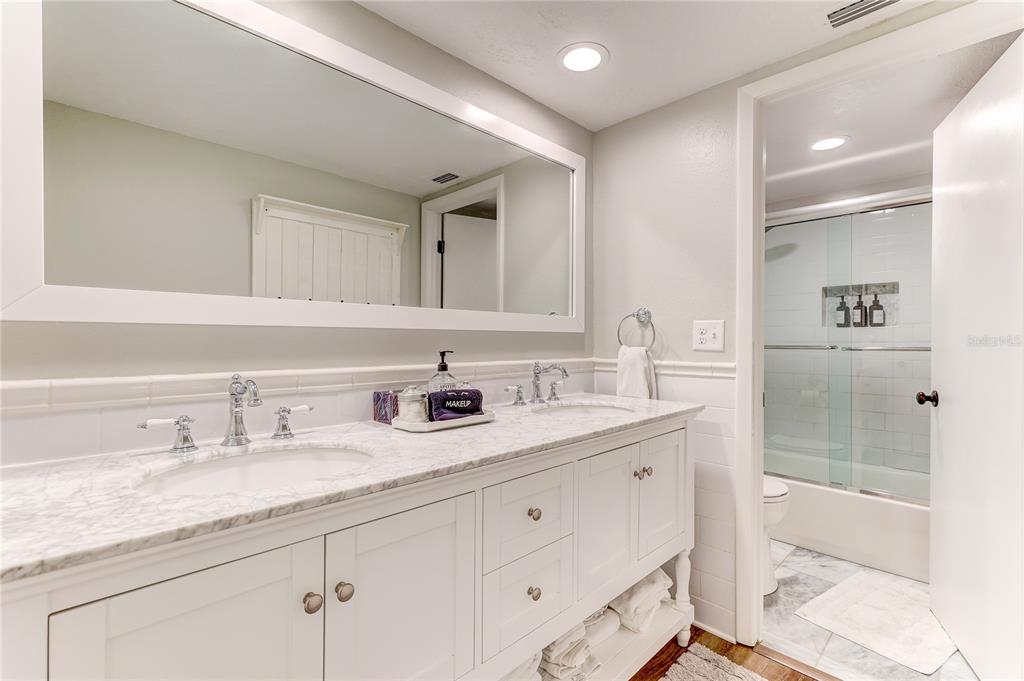 16332 Gulf Boulevard, Unit 1C Redington Beach, FL 33708 - Photo 31 of 90 a bathroom with double sink and a mirror
