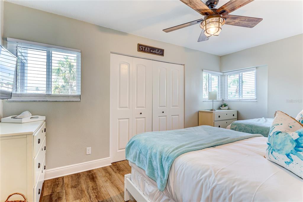 16332 Gulf Boulevard, Unit 1C Redington Beach, FL 33708 - Photo 36 of 90 a bedroom with a bed and a chandelier