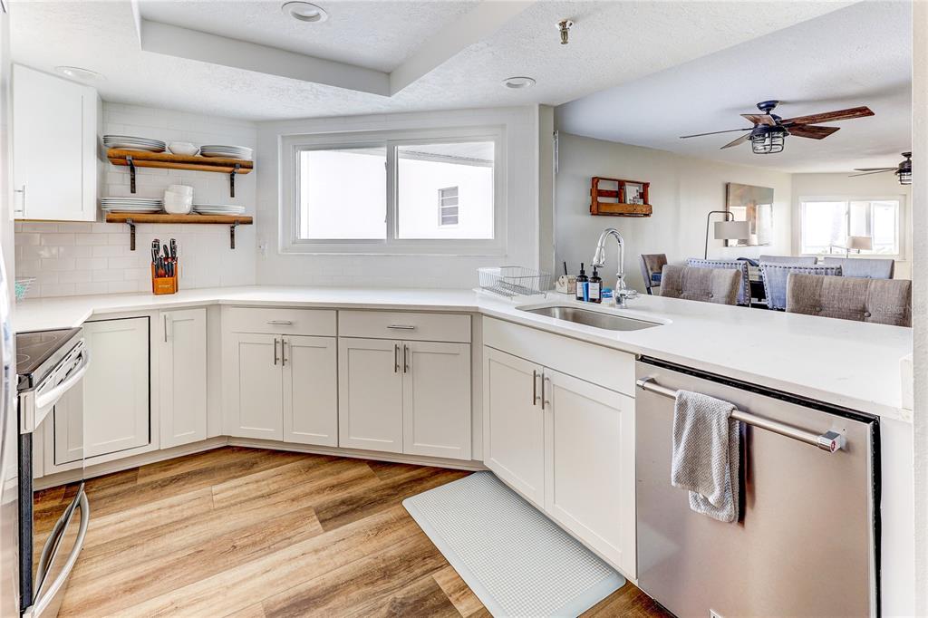 16332 Gulf Boulevard, Unit 1C Redington Beach, FL 33708 - Photo 41 of 90 a kitchen with white cabinets appliances and a window