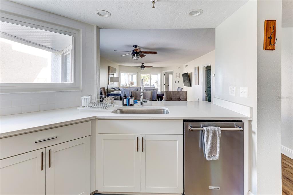 16332 Gulf Boulevard, Unit 1C Redington Beach, FL 33708 - Photo 43 of 90 a kitchen with white cabinets and chandelier