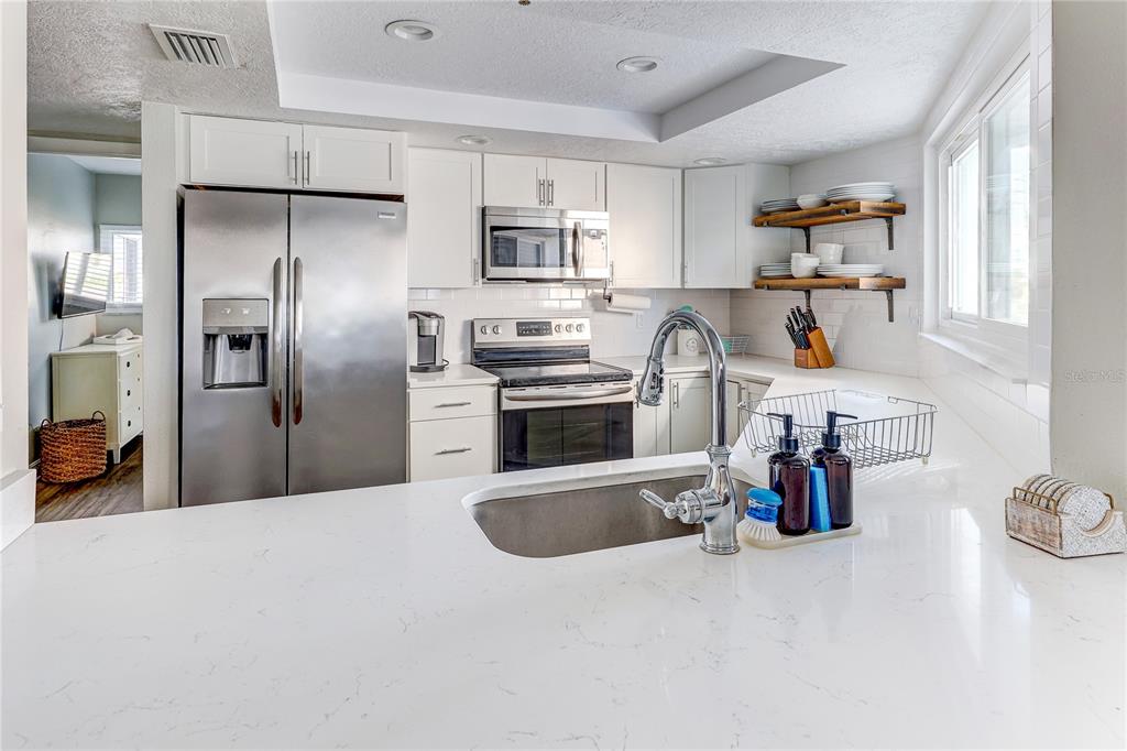 16332 Gulf Boulevard, Unit 1C Redington Beach, FL 33708 - Photo 46 of 90 a kitchen with refrigerator a microwave and sink