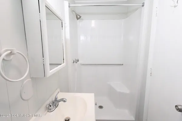 a bathroom with a sink a toilet and shower
