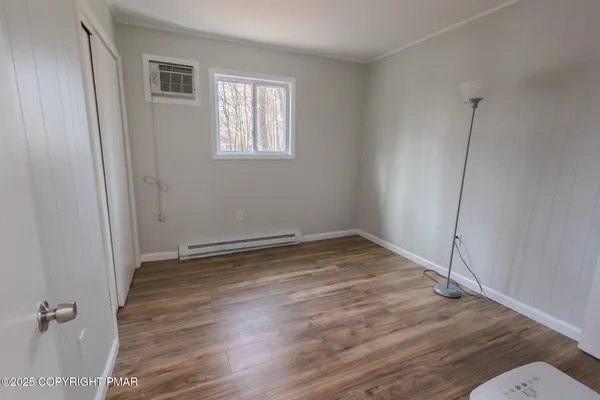 a view of a room with wooden floor and window