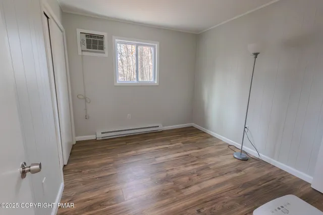 a view of a room with wooden floor and window