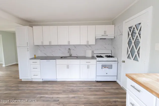 a kitchen with granite countertop white cabinets and white appliances