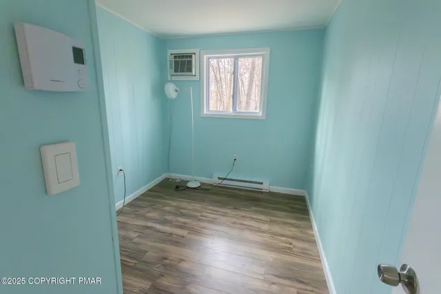 a view of empty room with wooden floor and cabinet