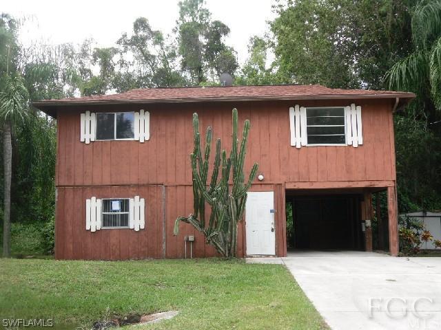 18812 Matanzas Road Fort Myers, FL 33967 - Photo 1 of 8 a front view of a house with a garden