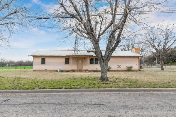 a white house that has a tree in front of it