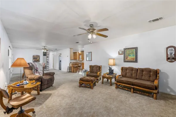 a living room with furniture ceiling fan and a rug