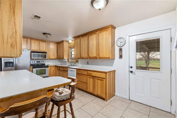 a kitchen with granite countertop a sink cabinets stainless steel appliances and a window