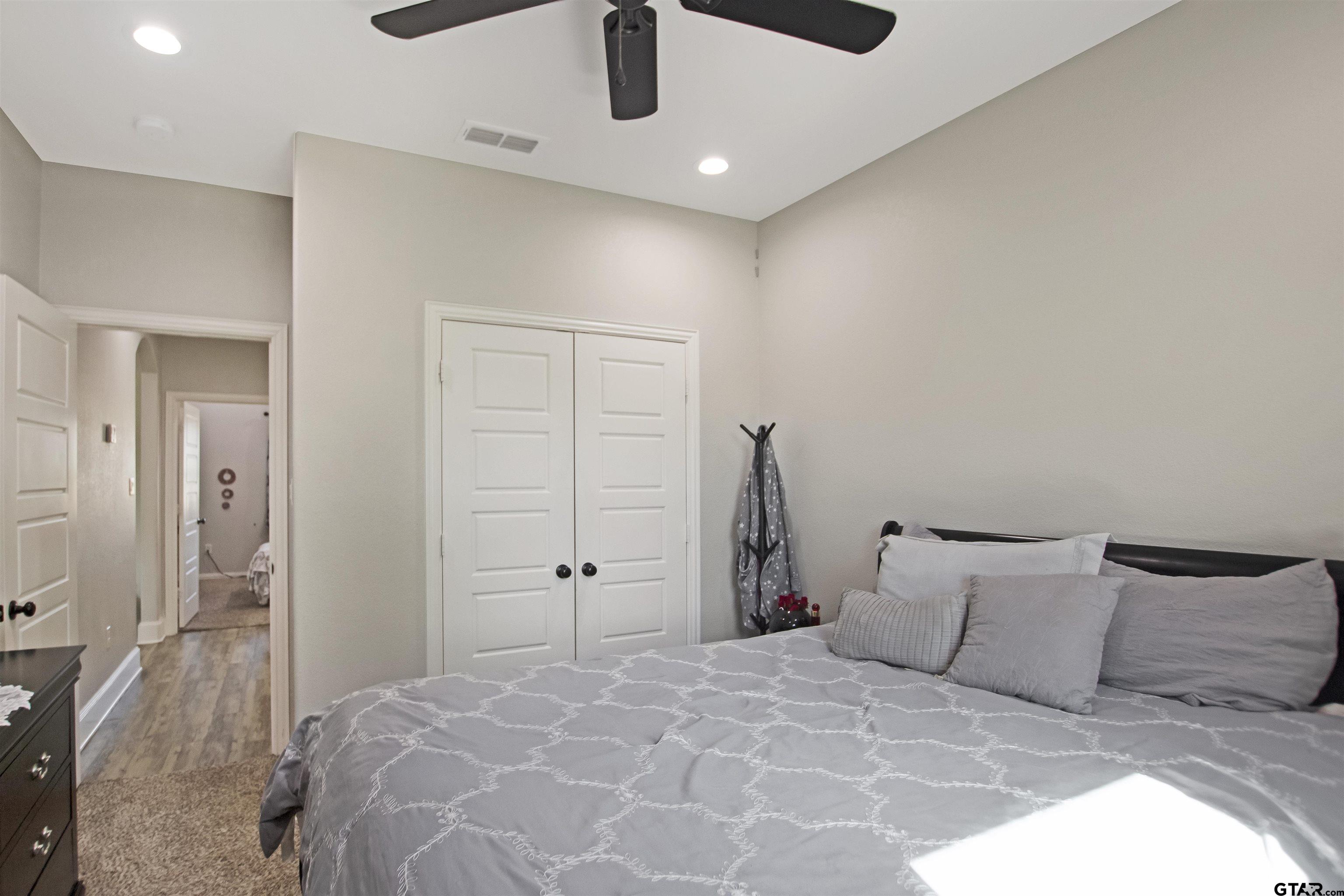 344 Duke Place Tyler, TX 75704 - Photo 22 of 36 a bedroom with a large bed and a chandelier
