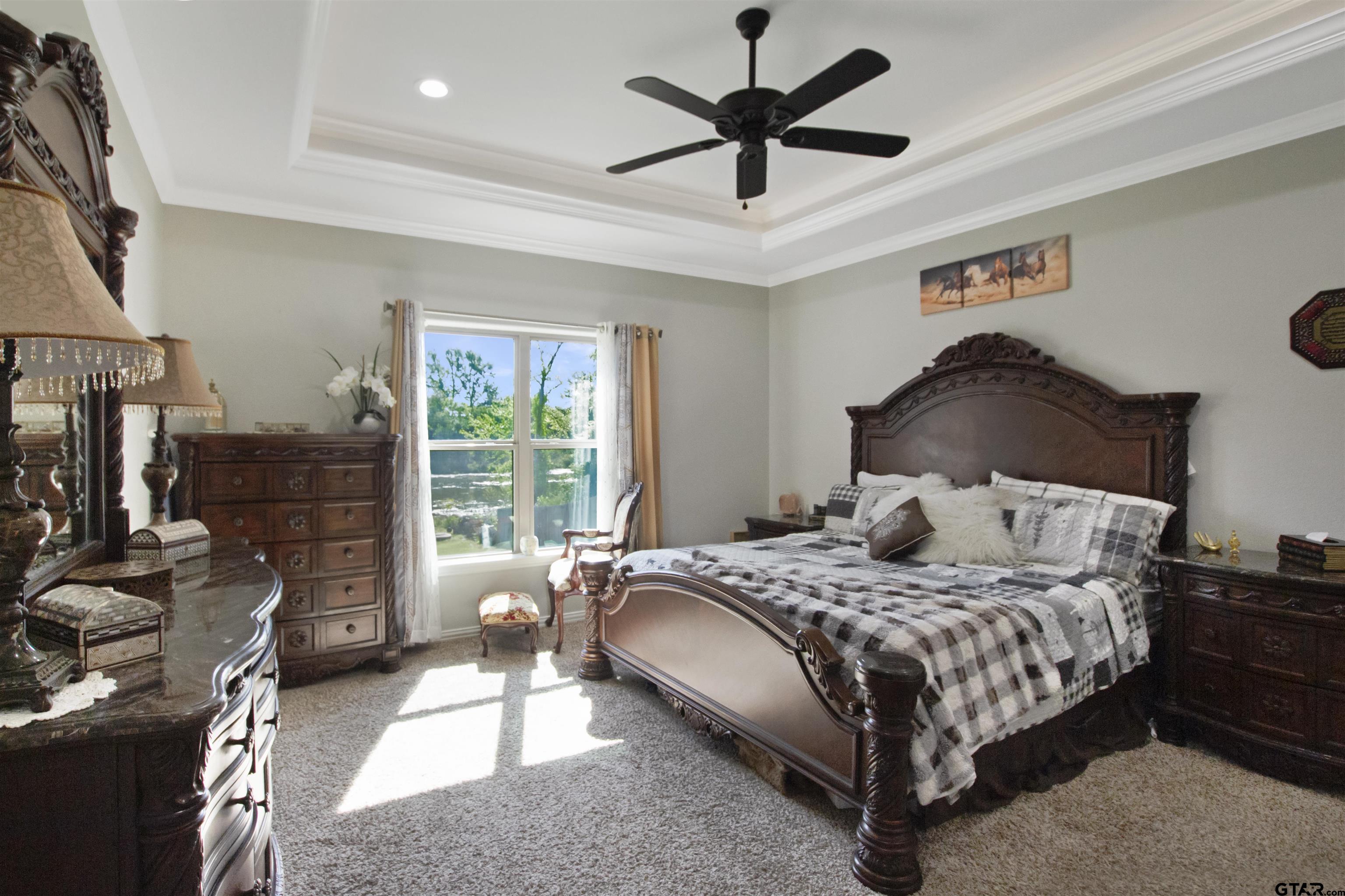 344 Duke Place Tyler, TX 75704 - Photo 23 of 36 a bedroom with a bed a chandelier and a flat screen tv