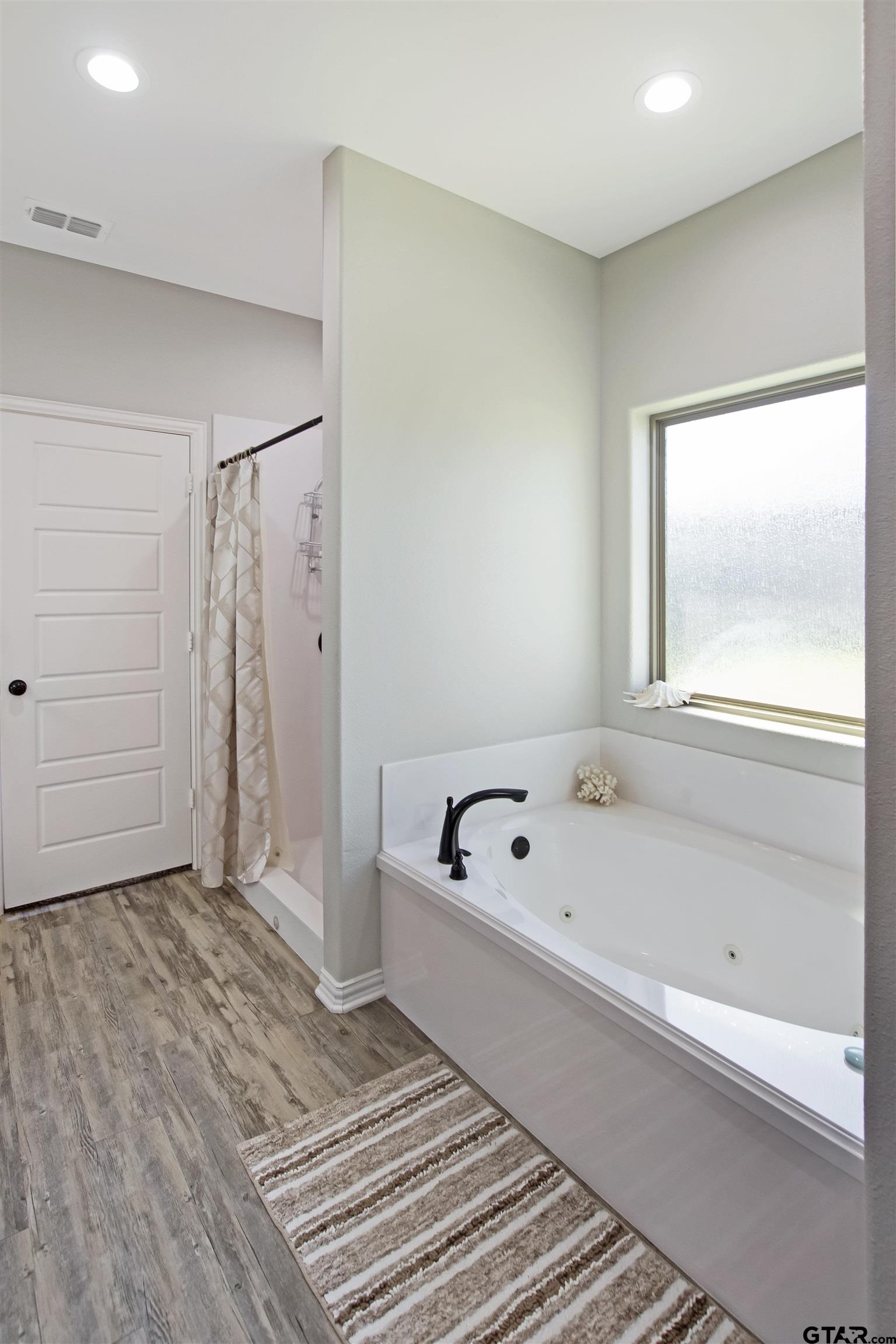 344 Duke Place Tyler, TX 75704 - Photo 27 of 36 a bathroom with a tub a window and a shower