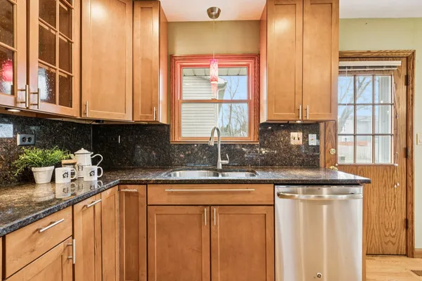 a kitchen with stainless steel appliances granite countertop a sink and a window