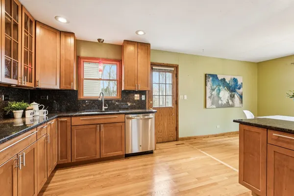 a large kitchen with stainless steel appliances granite countertop a stove a sink and a microwave