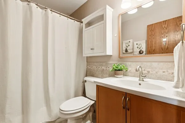 a bathroom with a sink a toilet and mirror