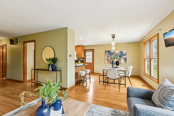 a living room with furniture dining table and wooden floor