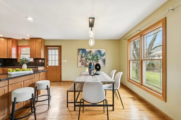 a dining room with furniture a chandelier and wooden floor