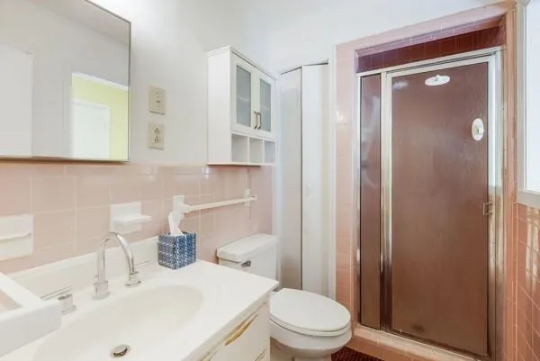 a bathroom with a sink a toilet and shower