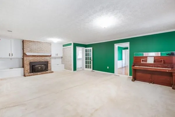 a view of an empty room with a fireplace and a window