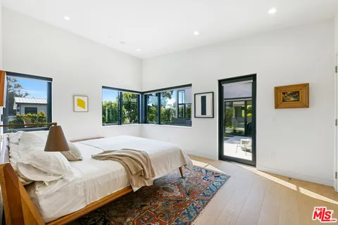 a bedroom with bed and glass window