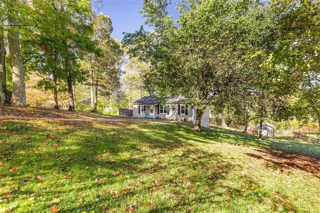 a view of yard with green space and trees all around