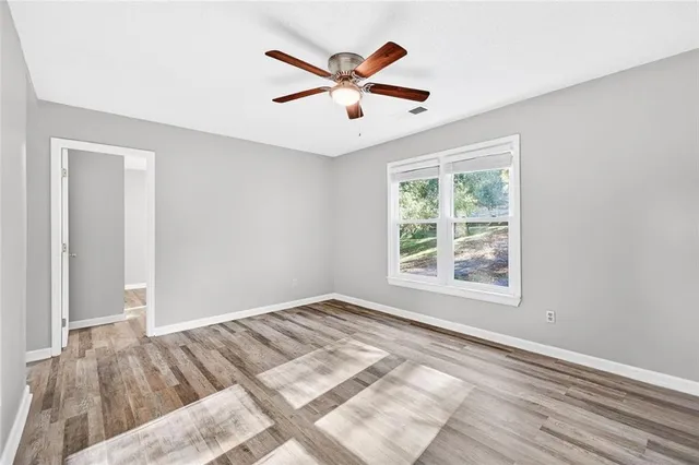 a view of a livingroom with a ceiling fan and wooden floor