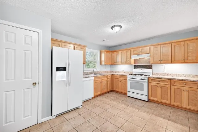 a kitchen with granite countertop appliances cabinets and a sink