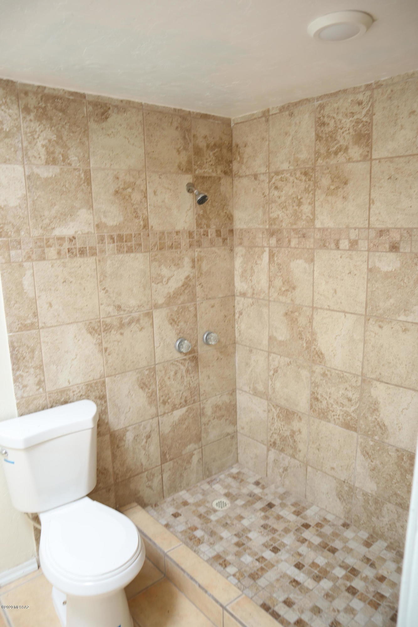 3536 South Mission Road Tucson, AZ 85713 - Photo 8 of 14 a white toilet sitting next to a shower