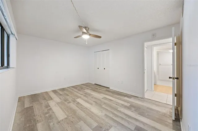 a view of a room with a ceiling fan and a window