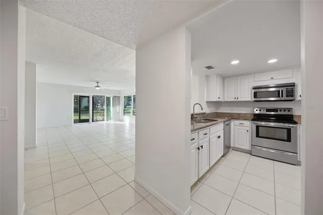a kitchen with granite countertop a stove top oven and cabinets